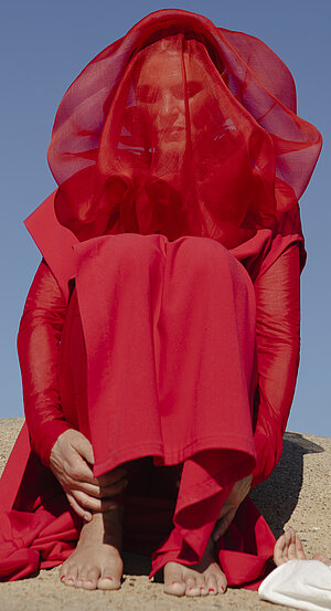 Bild på Gry Gry Worre Hallberg iklädd en heltäckande röd genomskinlig sjal