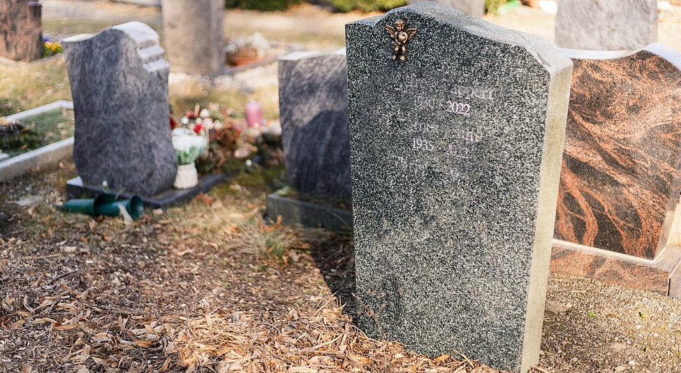 Bild med olika gravstenar på ute på en kyrkgård