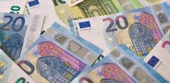 Close-up of a number of colourful euro banknotes of different denominations.
