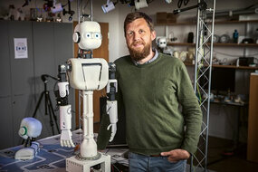 Kognitionsvetaren Birger Johansson står bredvid humanoidroboten EPI.