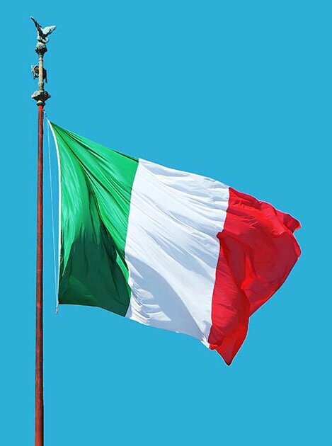 Den italienska flaggan vajar mot en blå himmel.