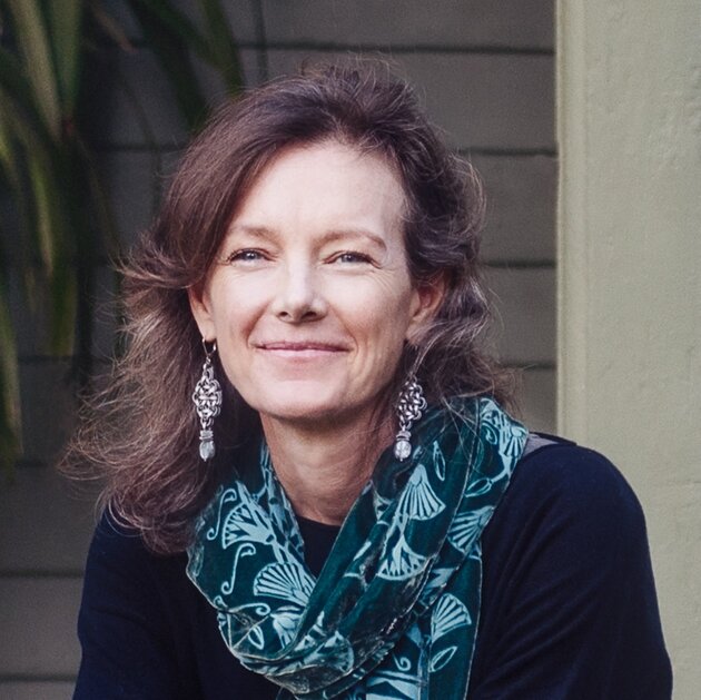 A portrait photo of a smiling woman with long brown hair