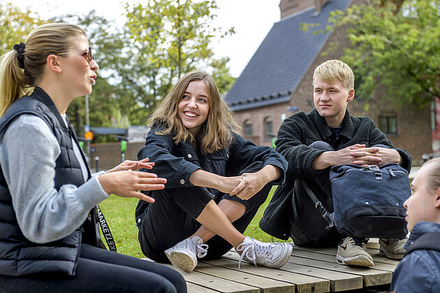 3 studenter samtalar utomhus