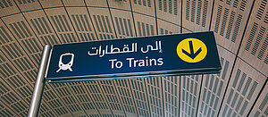 Vägskylt som visar vägen till tågen både på engelska och modern arabiska