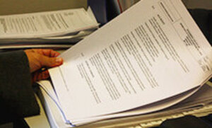 A holding a pile of application forms