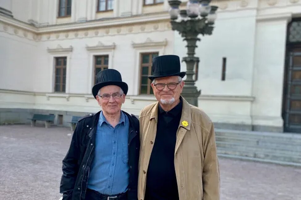 Bild på Göran Bexell och martin Lind utanför universitetshuset iförda doktorshatt.