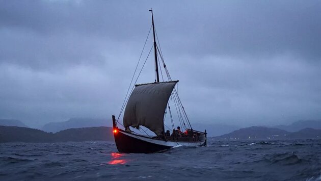 Vikingabåt ute på havet när det är natt.